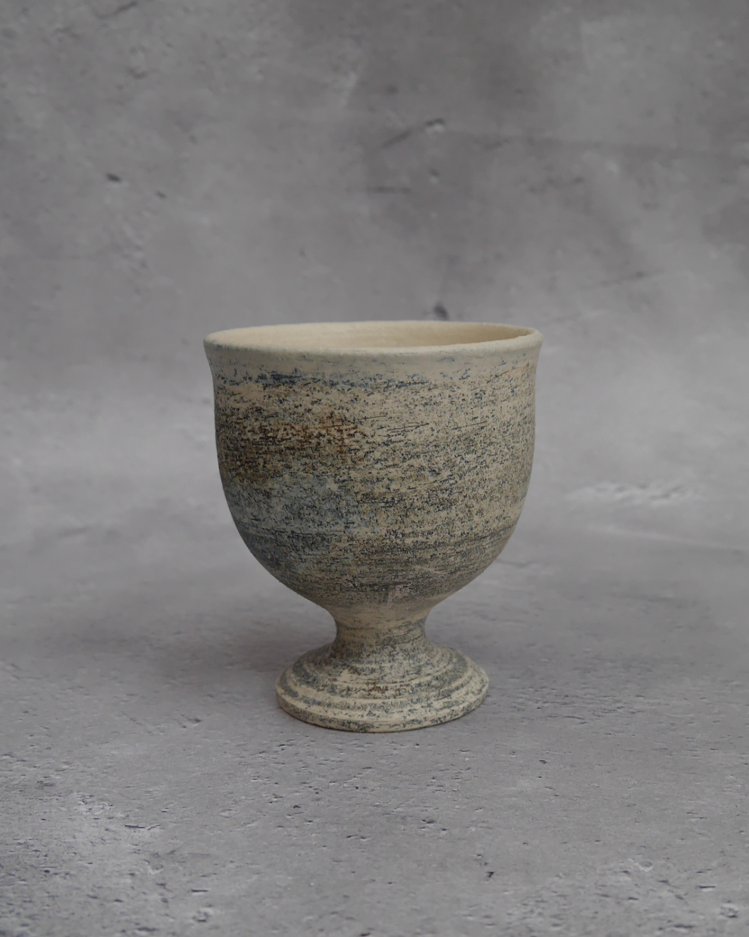 自然光に照らされたゴブレット「夜明けの海」。釉薬の重なりが美しく、静かな表情を見せる。