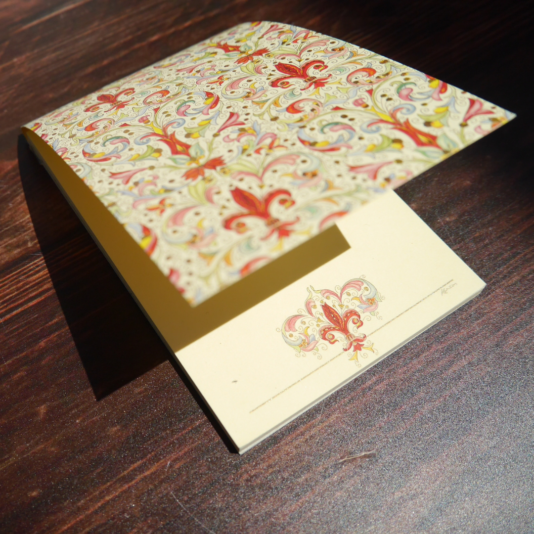 Kartos社のGiglio柄メモ。木の上で光を受け、赤と金の装飾が繊細にきらめく美しい紙文具。