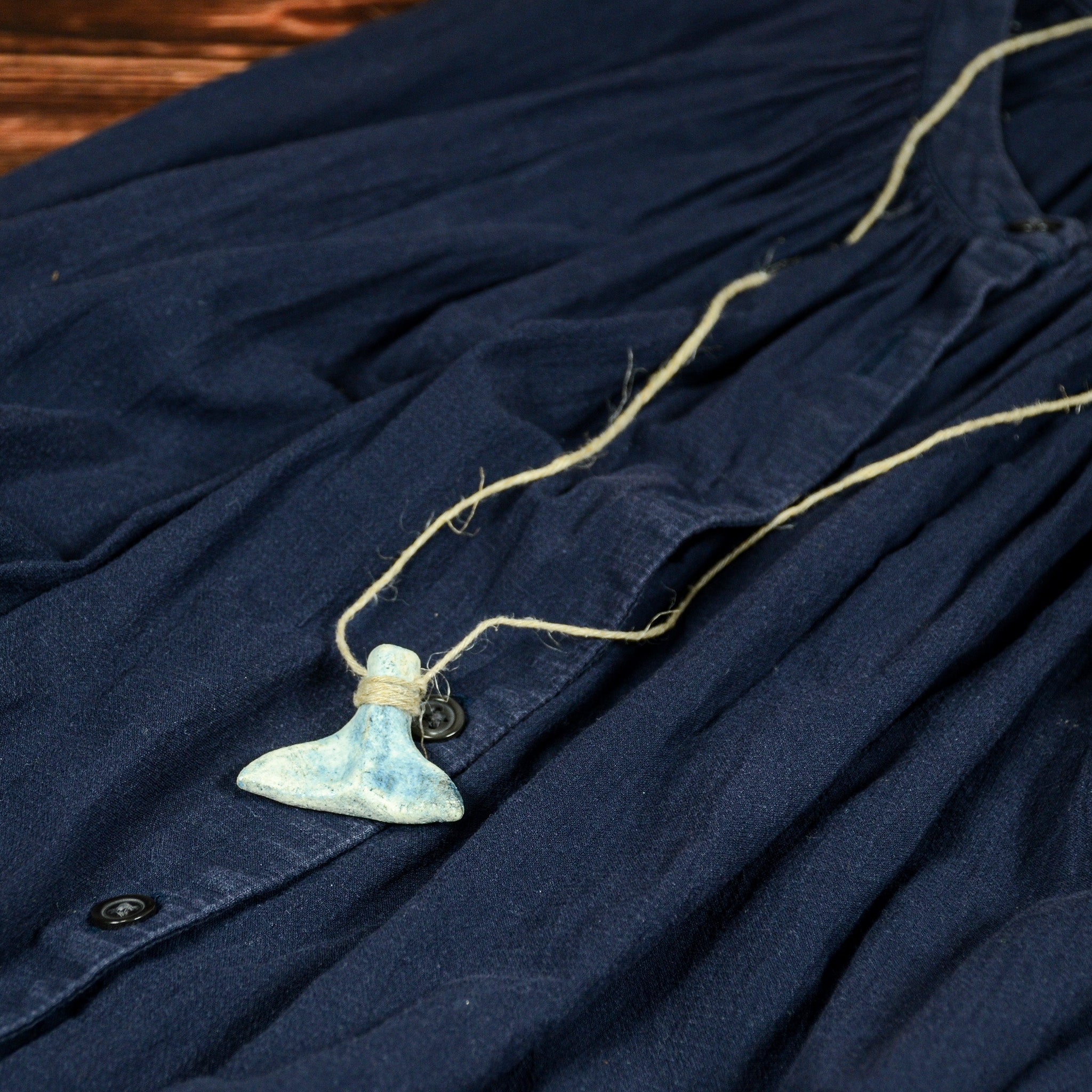 ネイビーの服に合わせた「くじらのしっぽ」オブジェ。ネックレスとして自然に馴染むサイズ感。