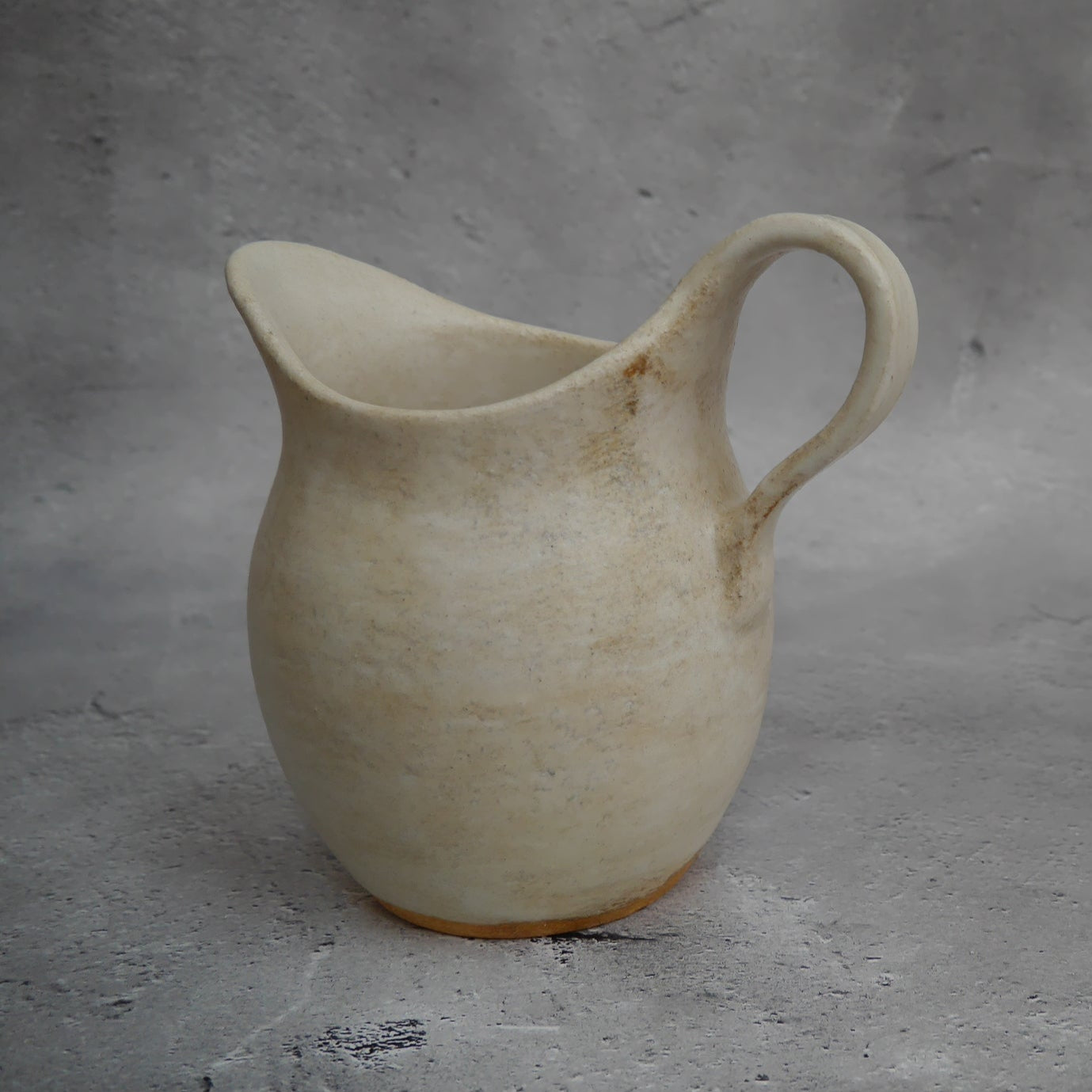 自然光のもとに佇む陶器の水差し「Sunlit」。明るく穏やかな印象のミドルサイズ。