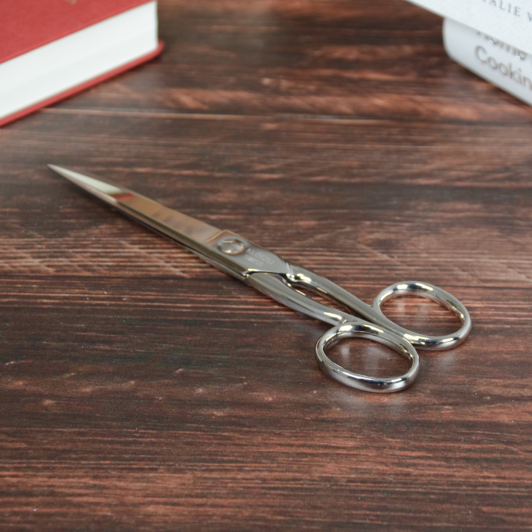 本と木のテーブルに置かれたハサミ。日常使いに溶け込む上品な佇まい