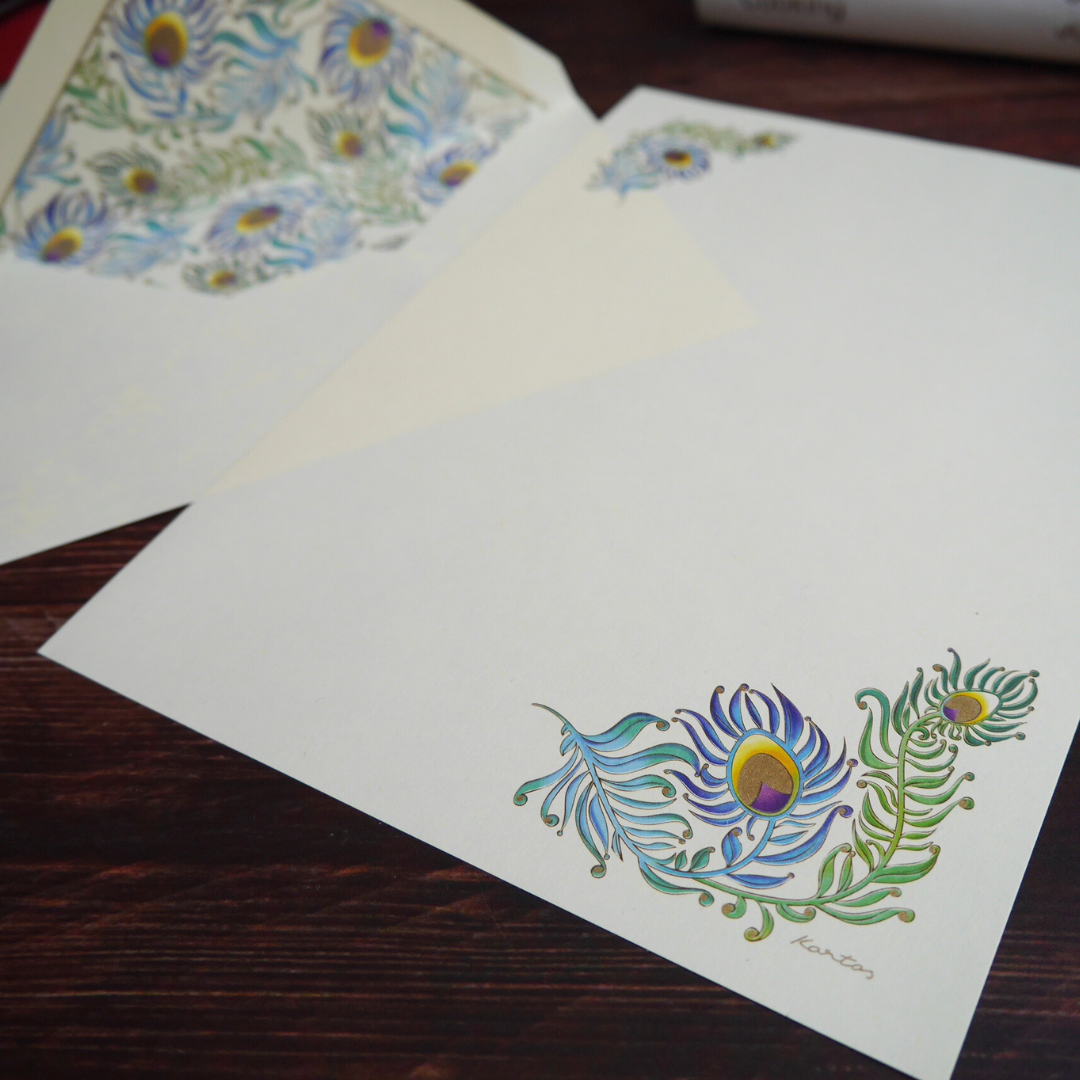 便箋下部の孔雀モチーフをクローズアップ。羽模様と植物の金粉装飾が上品な印象を与えます。