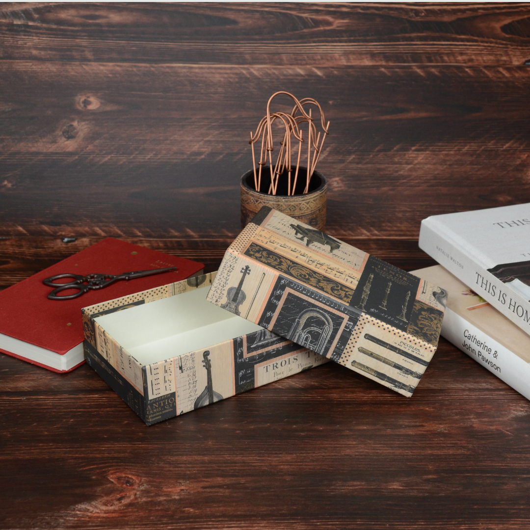 Melodia柄の文具箱を開いて、小物と一緒に撮影したライフスタイル風のカット。落ち着いた雰囲気