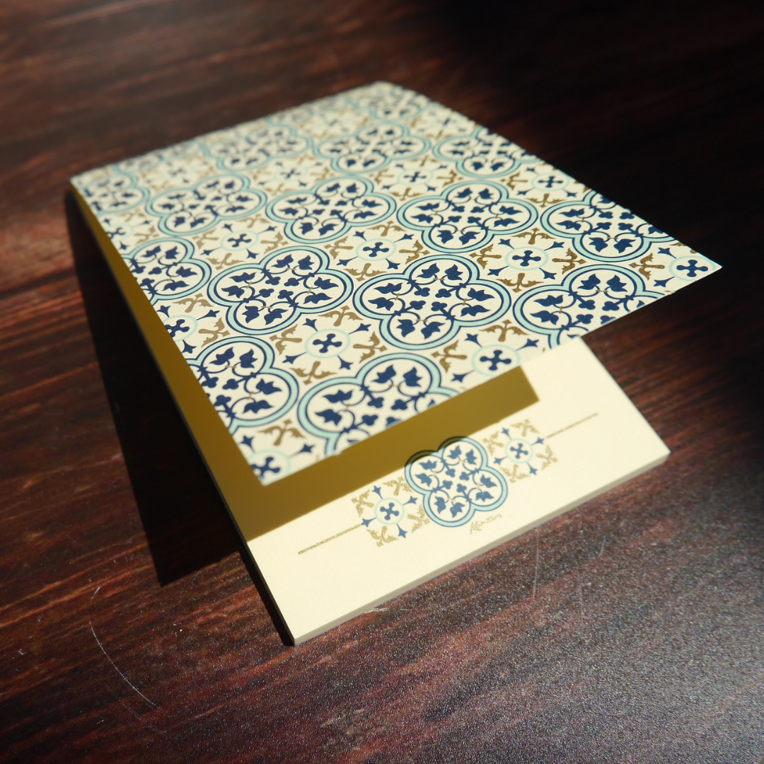 木の上に置かれたQuadrilobo柄のメモ。光の角度で金粉がやさしく輝く、美しいイタリア製紙文具。