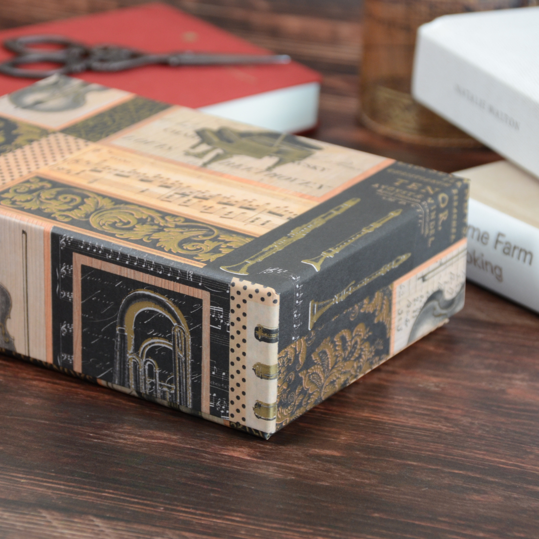 蓋を閉じた状態の文具箱を、木のテーブルの上で撮影。重厚感ある紙の質感が分かる構図