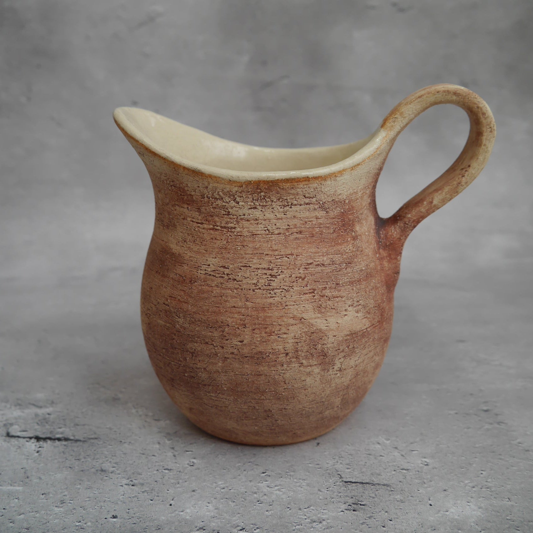 自然光に照らされた陶器の水差し「Earth」。ミドルサイズで、花器や日常の水差しとしても使える。